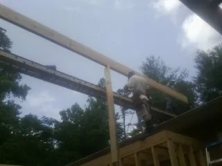 Carpenter setting a ridge beam over a new addition frame — Ice Dam Removal by Roofing Brothers in East Bernard
