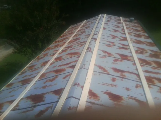 Rusted metal roof panels with new wood purlins before replacement — Storm Damage Roof Repair in East Bernard by Roofing Brothers