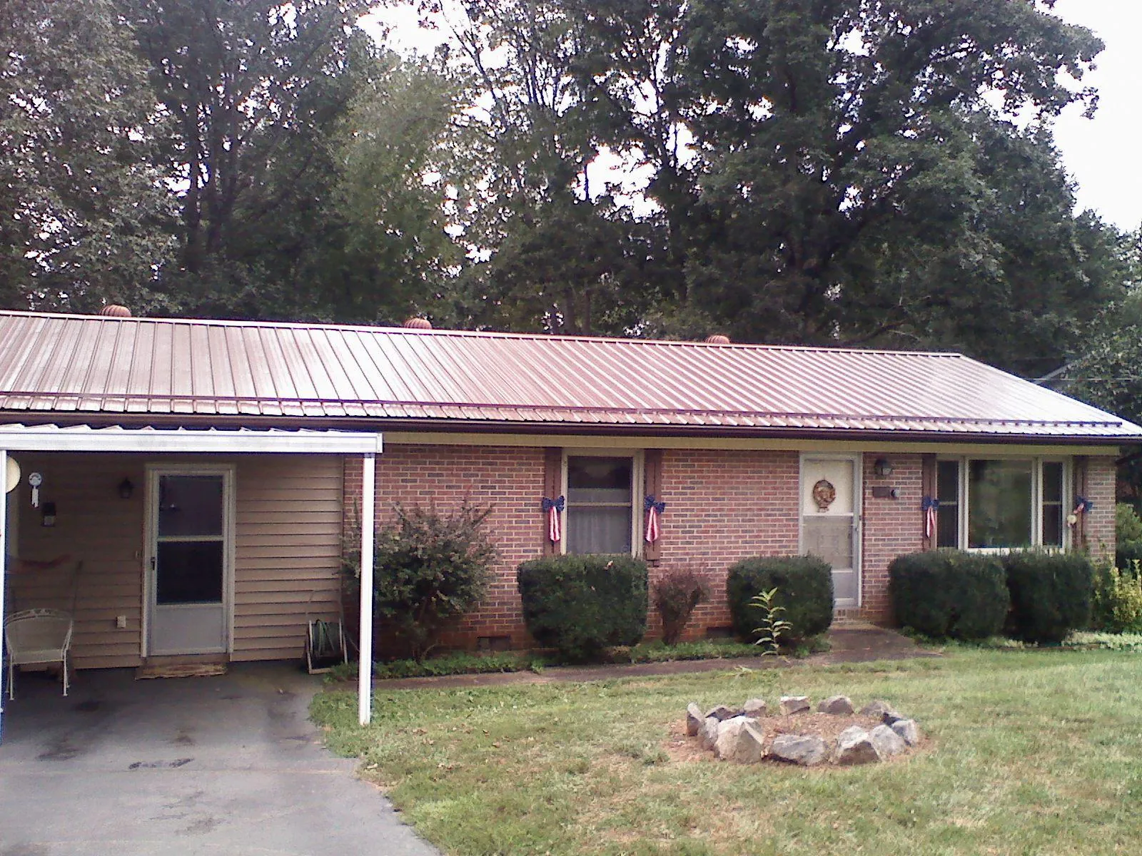 Bronze metal roof and carport on a brick ranch home — Roof Repair work by our crew in East Bernard